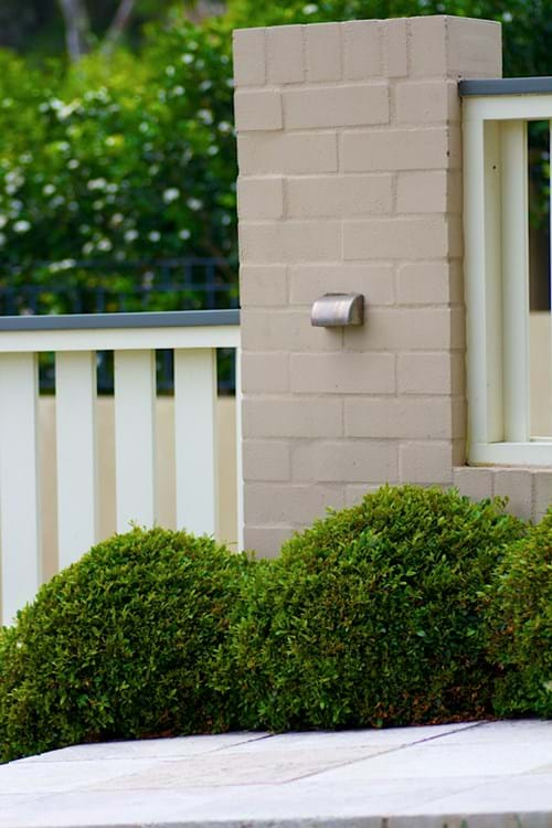 Painted brick pillars with slatted timber fence